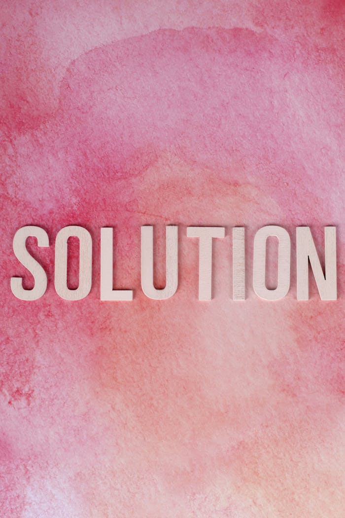 Inspirational Solution text on a vibrant pink watercolor background for motivation and problem-solving concepts.